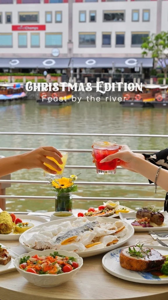 Guests toasting drinks over a Christmas Edition feast by the river at Zorba The Greek Taverna Singapore