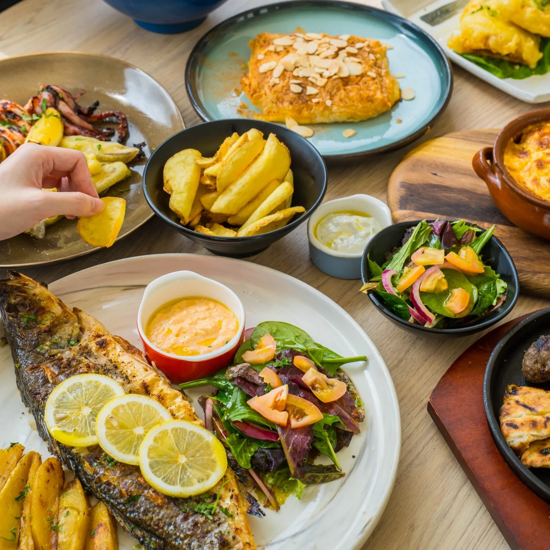 Greek feast of grilled sea bass, lemon potatoes, salads and dips at Zorba The Greek Taverna Clarke Quay Singapore