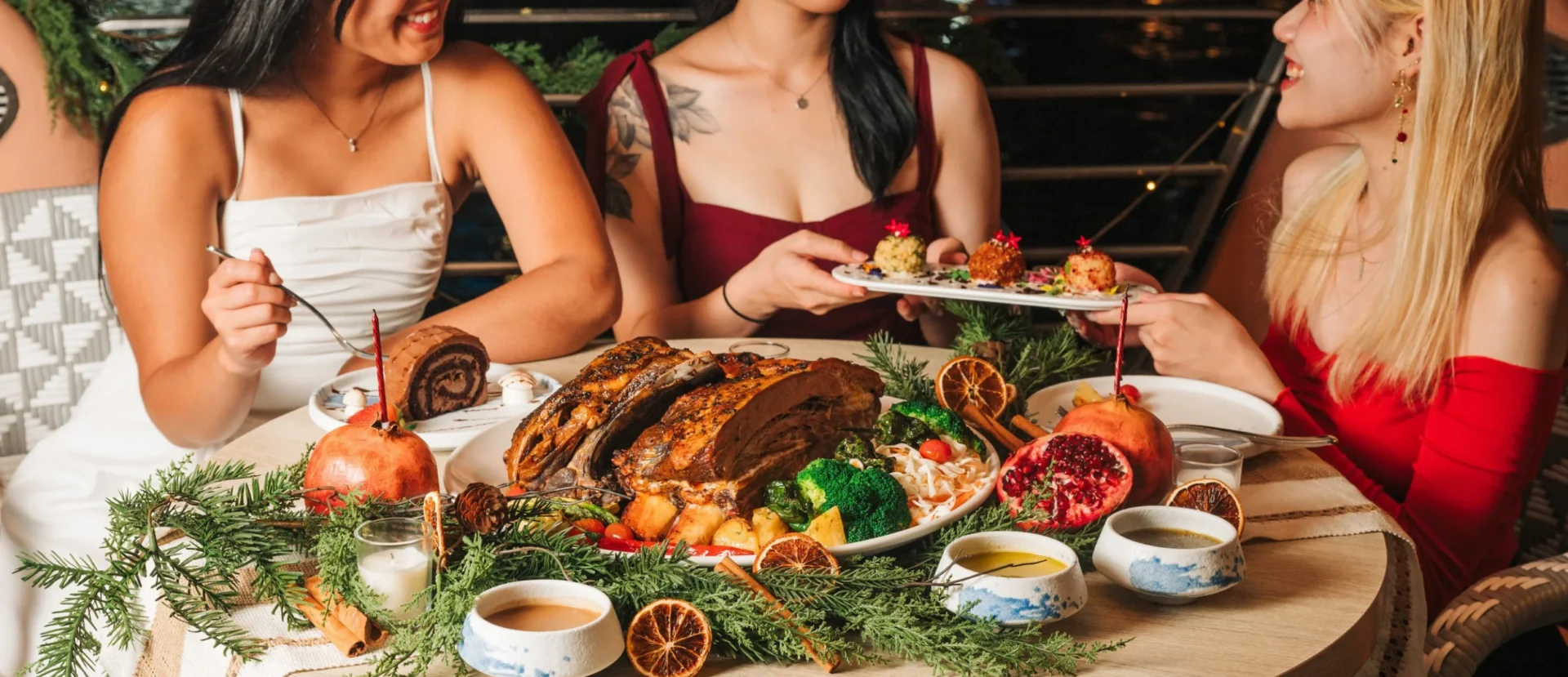 Friends sharing a festive Christmas feast with roast meat, pomegranates and oranges at Zorba The Greek Taverna Clarke Quay Singapore